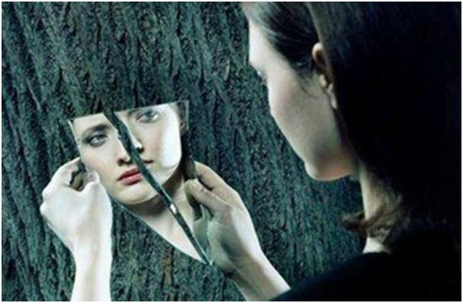 девушка смотрит в разбитое зеркало