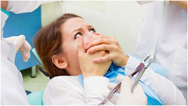 испуганная девушка в кресле у стоматолога